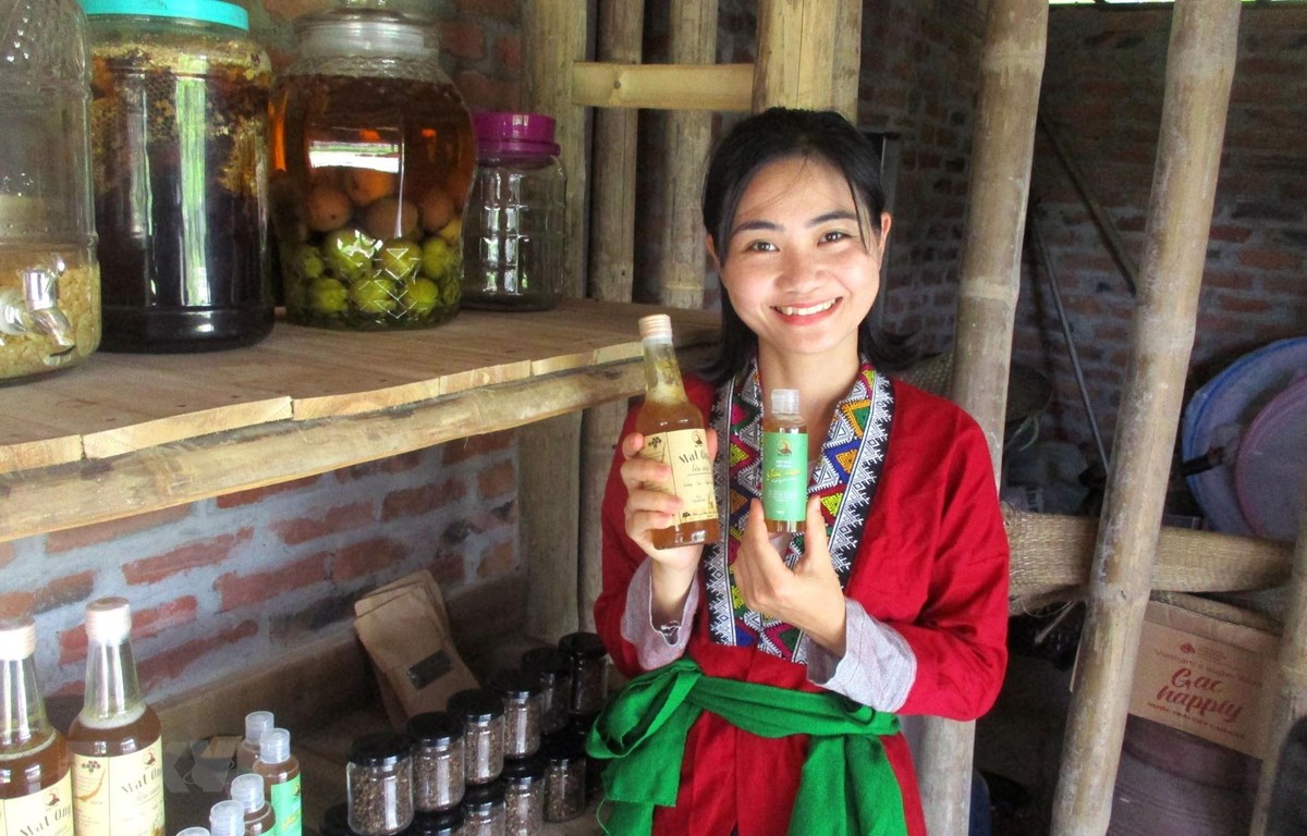 Chị Nguyễn Lê Ngọc Linh và sản phẩm mật ong sạch của Vườn rừng bản Thổ. (Ảnh: Nguyễn Nam/TTXVN)